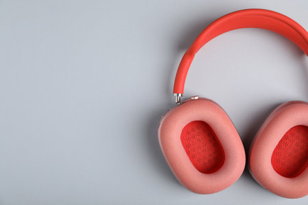 Pair of stylish pink headphones on light gray background, top view. Space for textの写真素材