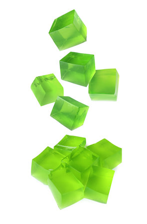 Yummy green jelly cubes falling on white backgroundの写真素材