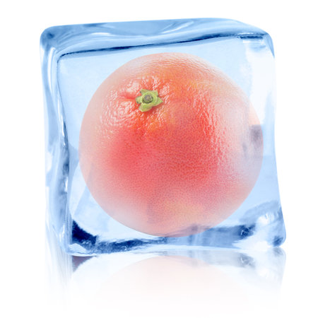 Fresh grapefruit inside ice cube on white backgroundの写真素材