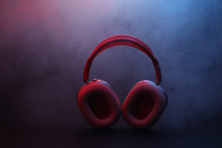 Pair of wireless headphones on dark background with color lights