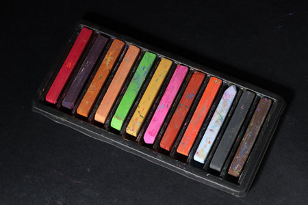 Set of colorful chalk pastels on black background
