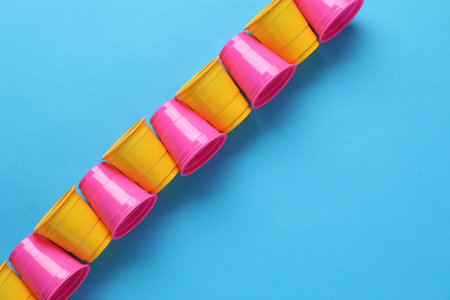 Set of disposable cups on light blue background, flat layの写真素材