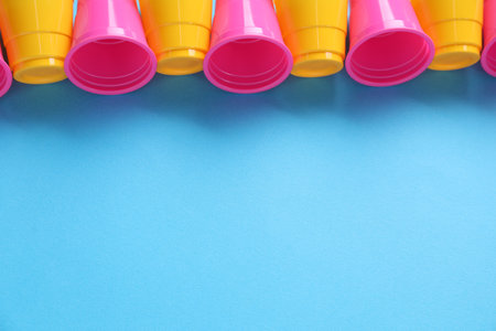 Set of disposable plastic cups on light blue background. Space for textの写真素材