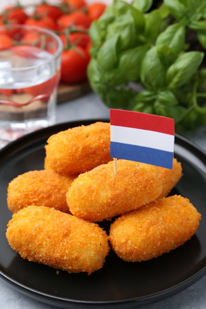 Delicious fried croquettes, tomatoes and basil on table, closeupの写真素材