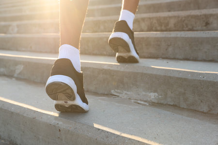 Teenage boy running up stairs outdoors, closeupの写真素材