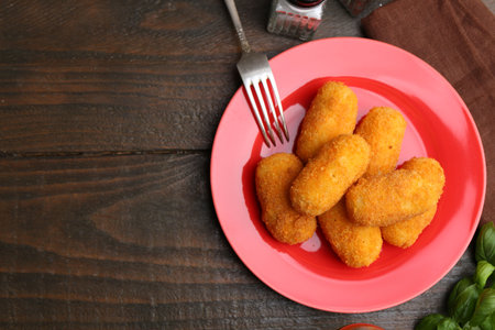 Delicious fried croquettes served on wooden table, flat lay. Space for textの写真素材
