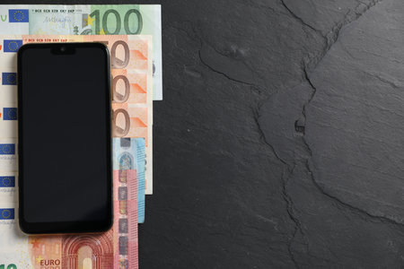 Smartphone and money on black table, flat lay. Space for textの写真素材