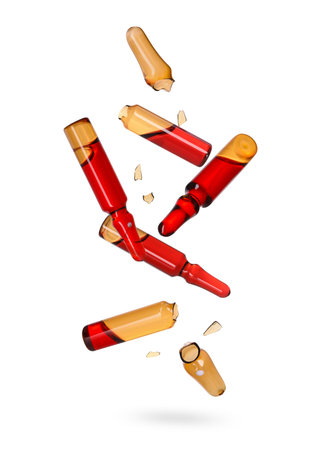 Many ampoules and glass pieces falling on white backgroundの写真素材