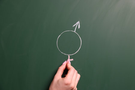 Sex Education. Woman drawing gender symbol on green chalkboard, closeupの写真素材