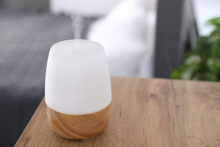 One stylish aroma lamp on wooden table indoors, closeup