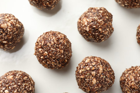 Tasty chocolate candies with nuts on white table, flat lay