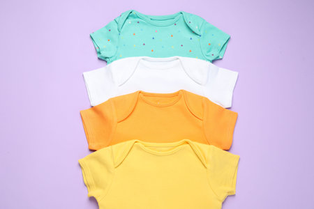 Stylish baby clothes on violet background, flat layの写真素材