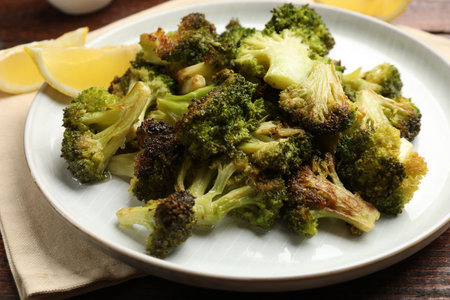 Tasty fried broccoli and lemon on wooden table, closeupの写真素材