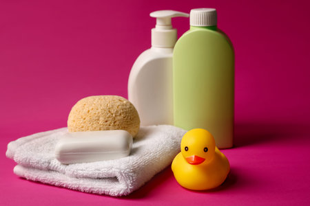 Baby bath accessories and care products on crimson background, closeup