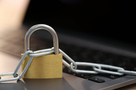 Cyber safety. Metal padlock with chain on laptop, closeup. Space for text