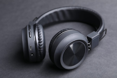Pair of stylish headphones on black background, closeup
