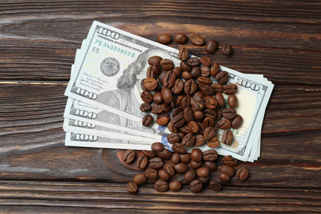 Roasted coffee beans and dollar banknotes on wooden table, flat layの写真素材