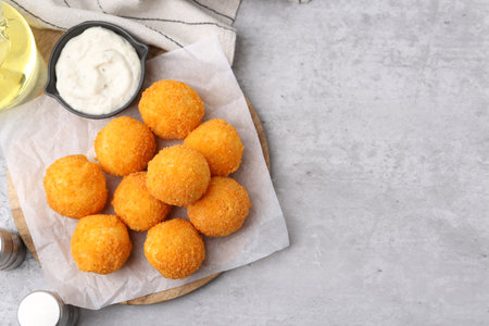 Delicious fried croquette balls, sauce, oil and spices on gray textured table, flat lay. Space for textの写真素材