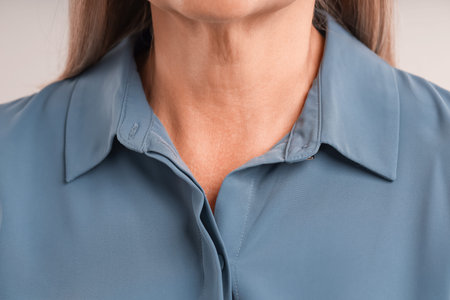 Woman with healthy skin on light background, closeup