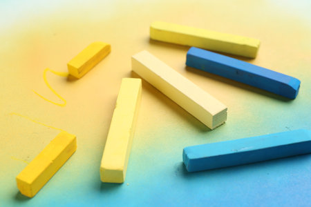 Yellow and light blue chalk pastels on color background, closeupの写真素材