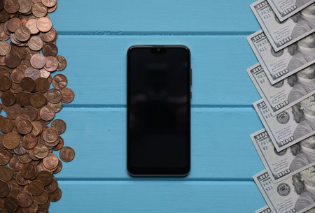 Smartphone and money on blue wooden table, flat layの写真素材
