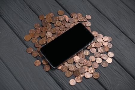 Smartphone and money on gray wooden table, closeupの写真素材