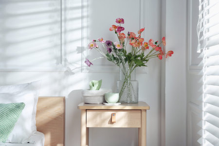 Bedside table with different decor near bed indoorsの写真素材
