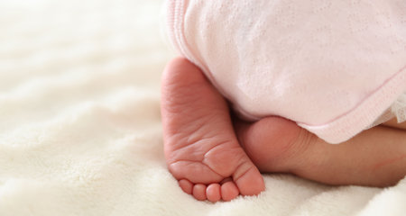 Cute newborn baby lying on bed, closeup. Space for textの写真素材