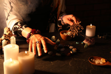 Woman doing ritual with healing stones at dark table, closeupの写真素材
