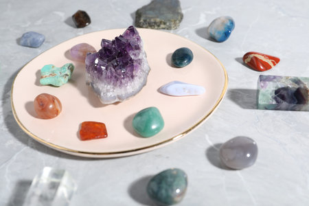 Many different healing stones on light gray table, closeup