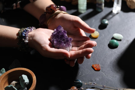 Woman with healing stones at black table, closeupの写真素材