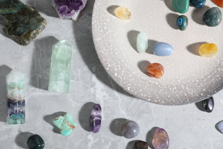 Many different healing stones on light gray table, flat layの写真素材