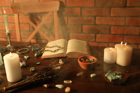 Healing stones, book, lavender and burning candles on wooden tableの写真素材