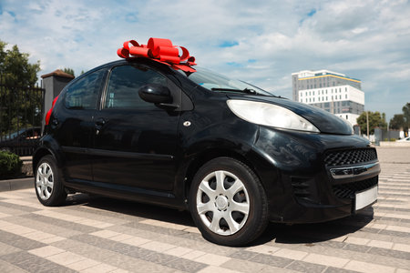 Dreams come true. New auto with big red bow outdoorsの写真素材