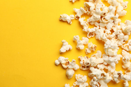 Tasty popcorn on yellow background, flat lay. Space for textの写真素材