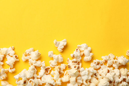 Tasty popcorn on yellow background, flat lay. Space for textの写真素材