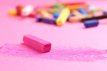 Many colorful chalk pastels on pink background, closeupの写真素材