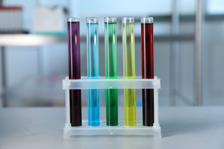 Test tubes with color liquids on light table in laboratory