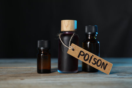 Bottles of poisons on wooden table against dark background, closeupの写真素材