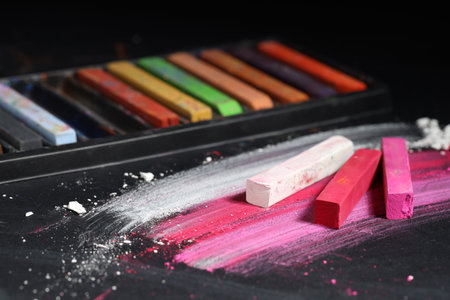 Many colorful chalk pastels on black background
