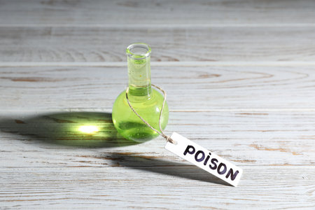 Flask with poison on wooden table, closeupの写真素材