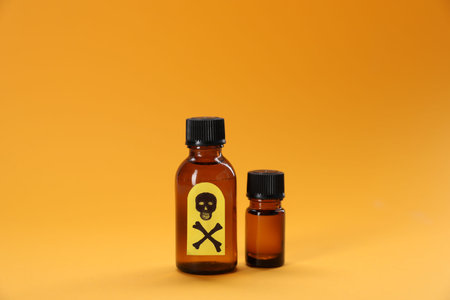 Bottles of poisons with warning sign on orange backgroundの写真素材