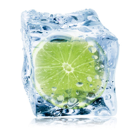 Cut fresh lime fruit in ice cube isolated on whiteの写真素材