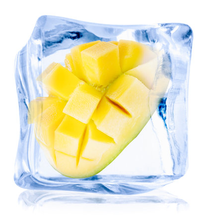 Cut juicy mango in ice cube isolated on whiteの写真素材
