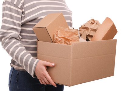 Recycling. Woman holding cardboard box with different waste paper on white background, closeup