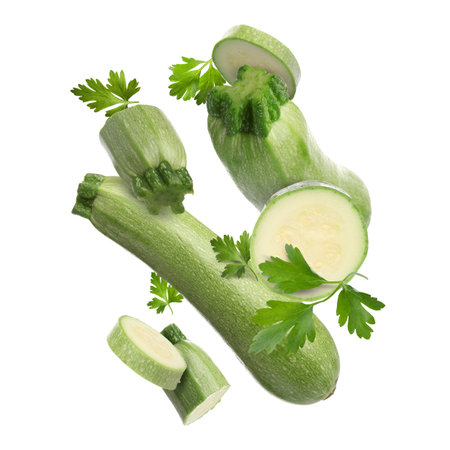 Fresh zucchinis and parsley falling on white backgroundの写真素材