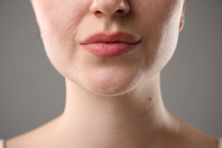 Woman before cosmetic procedure on grey background, closeupの写真素材