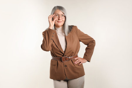 Portrait of beautiful senior woman on light backgroundの写真素材