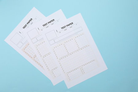 Answer sheets on light blue background, flat lay. Student passing examの写真素材