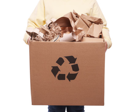 Recycling. Woman holding cardboard box with different waste paper on white background, closeupの写真素材